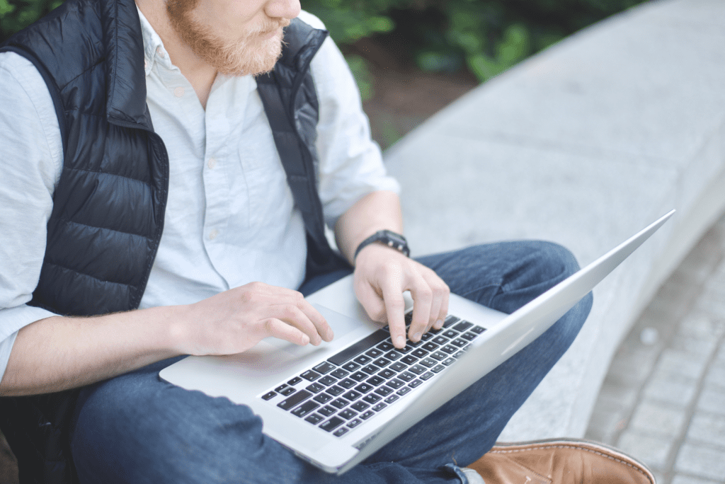 man learning to program on laptop outside